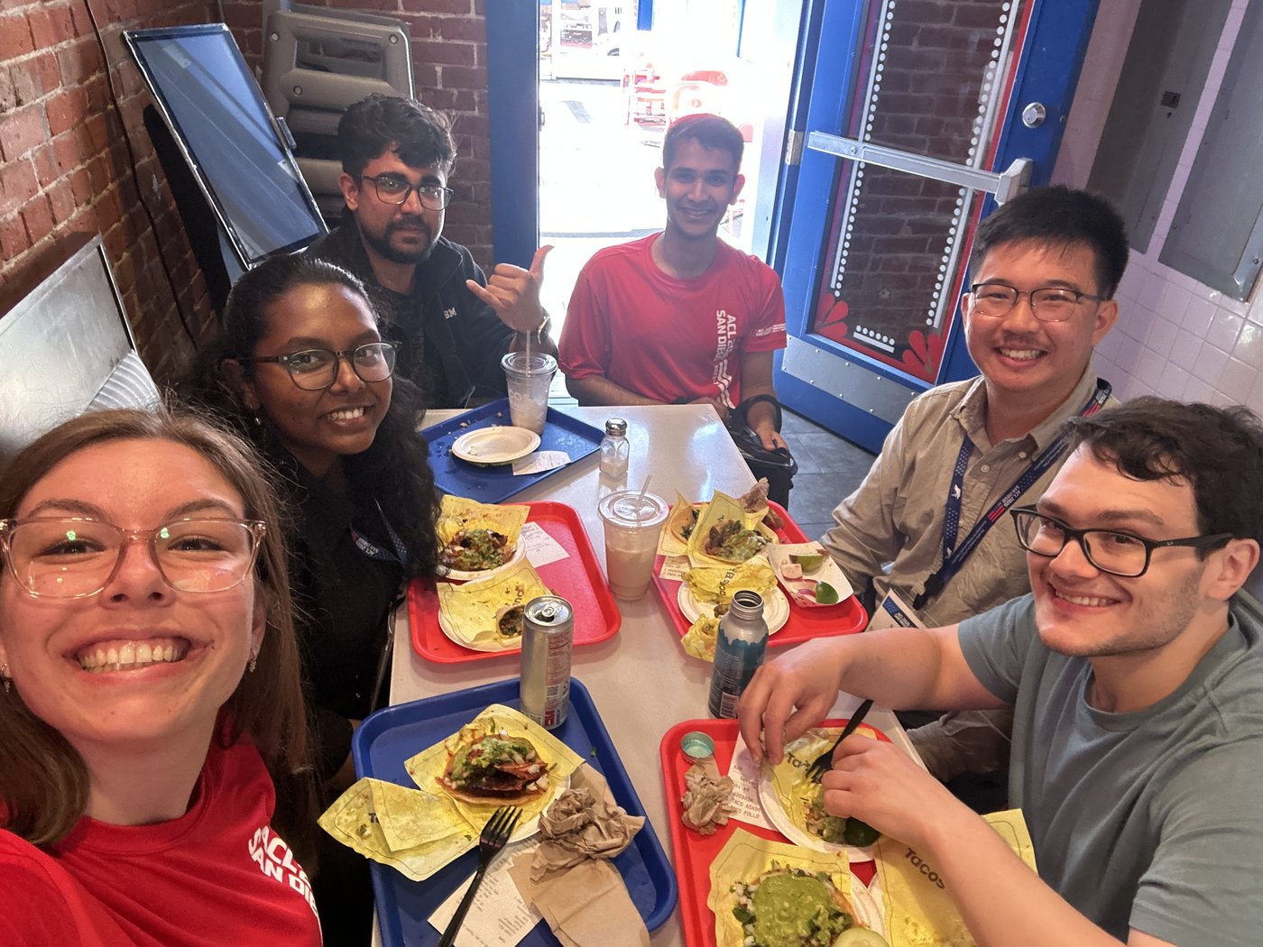 Anna and friends around a table full of tacos mid-conference.