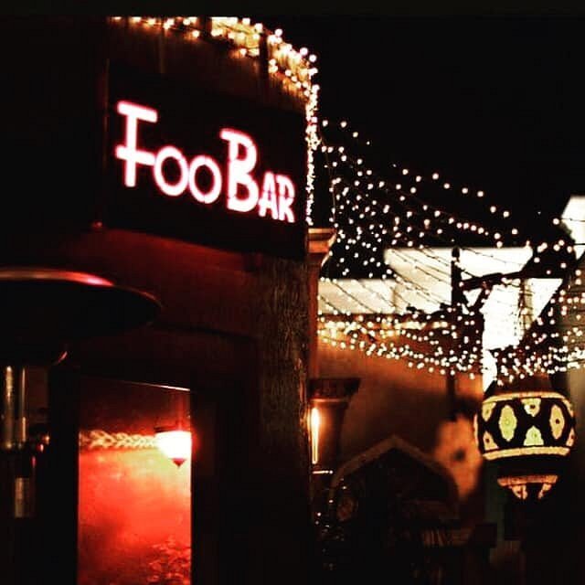 A glowing red FooBar sign at night, surrounded by string lights.