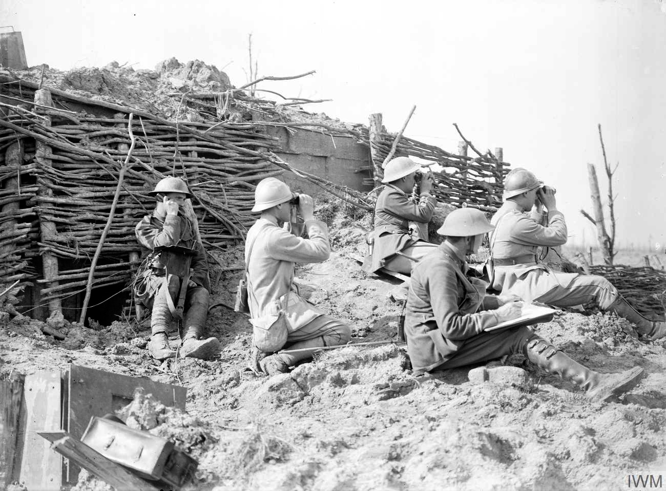 British and French artillery forward observation officers with binoculars, and a British field telephonist, at the Battle of Langemarck, 16 August 1917. Photo by Ernest Brooks, Imperial War Museums Q 2723; public domain, via Wikimedia Commons.