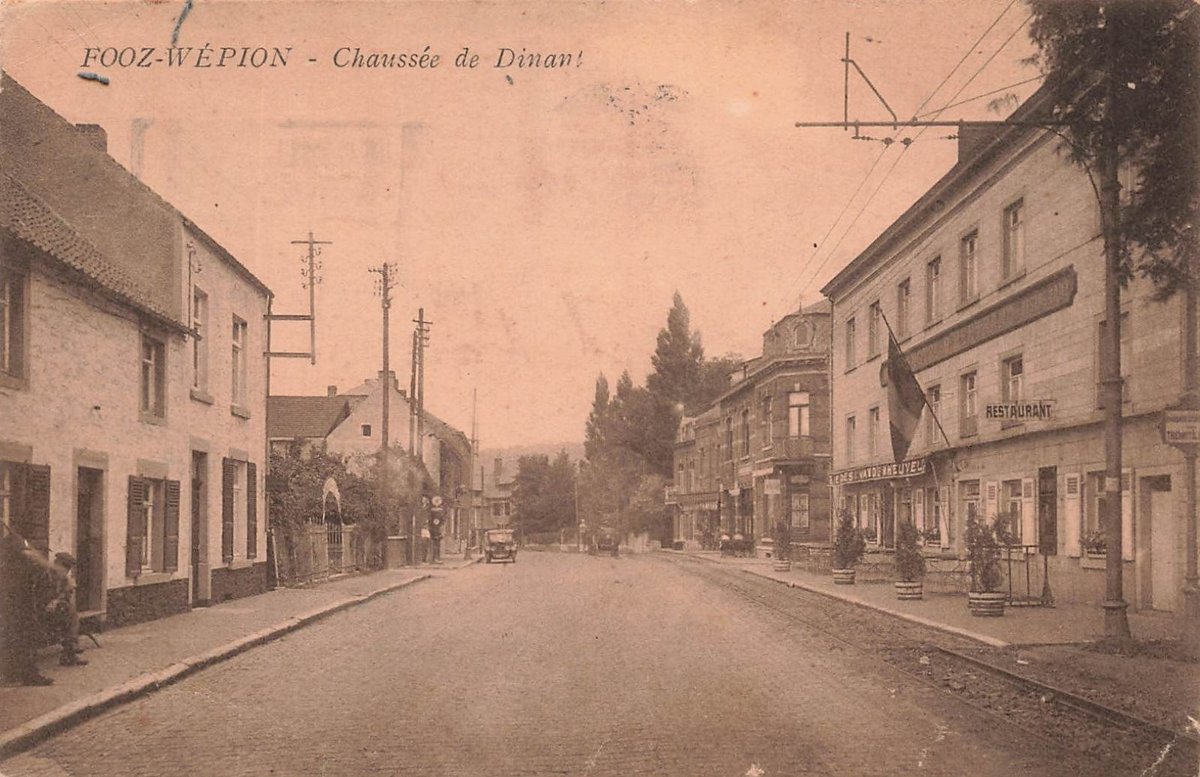 An old postcard of Fooz-Wépion: the Chaussée de Dinant, a village street with houses and tram wires. Public domain, via Wikimedia Commons.