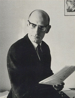 Michel Foucault in glasses and a tweed jacket, holding a sheaf of papers; the author photo from the 1970 dust jacket of The Order of Things. Public domain, via Wikimedia Commons.