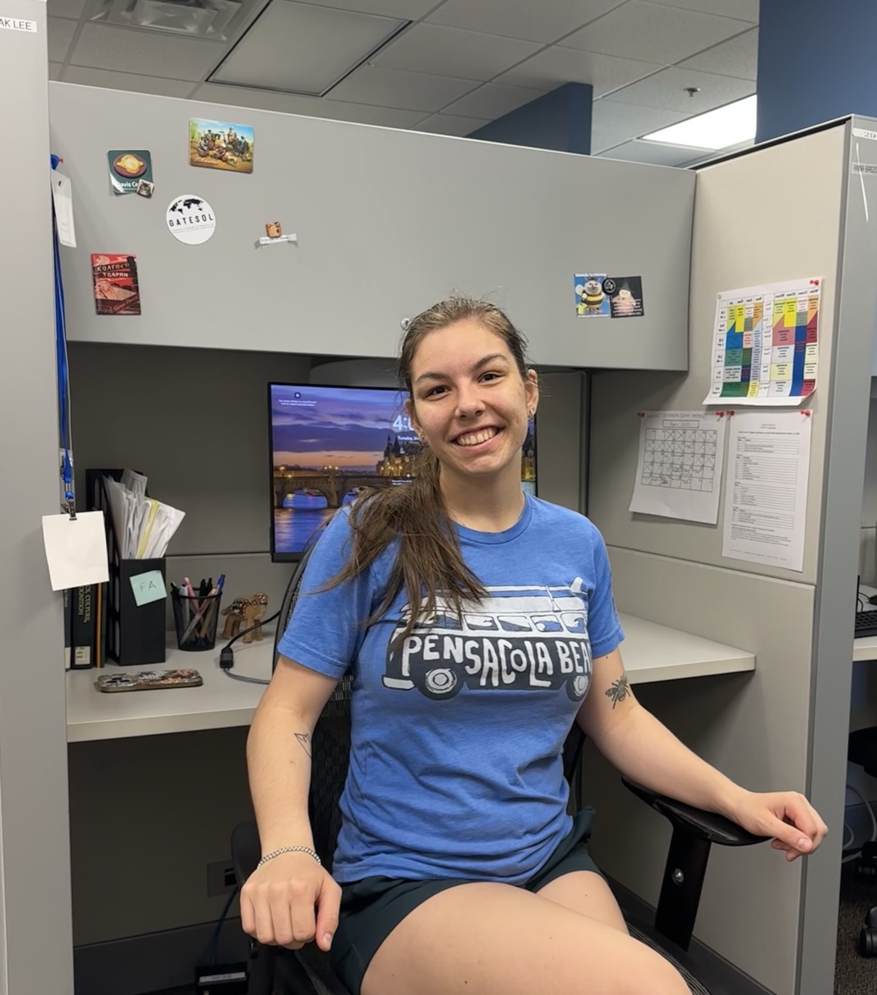 Anna smiling at her desk in the Applied Linguistics department office.